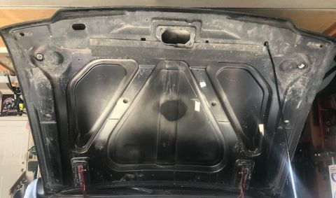 2000 Ford Explorer - The underside of a car hood is shown, with visible dust and smudges on its surface.
