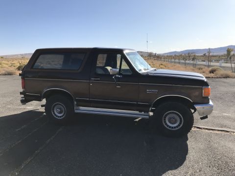 1988 Ford Bronco - This 1988 Ford Bronco features a two-tone paint scheme with wood paneling on the side.