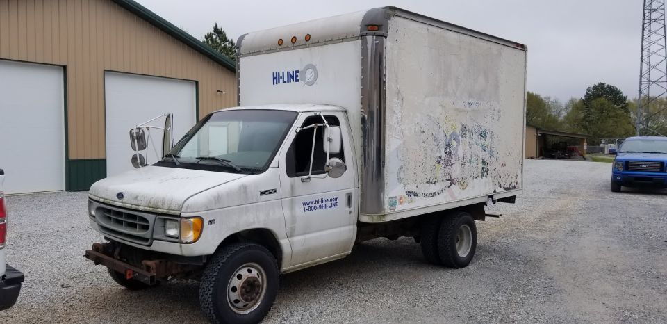 White 1998 Ford E350 box truck parked outside a building