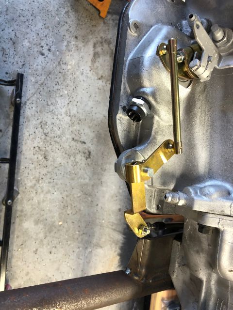 1992 Jeep Wrangler - Transmission linkage assembly with brass levers and a metal rod, likely for a vehicle drivetrain.