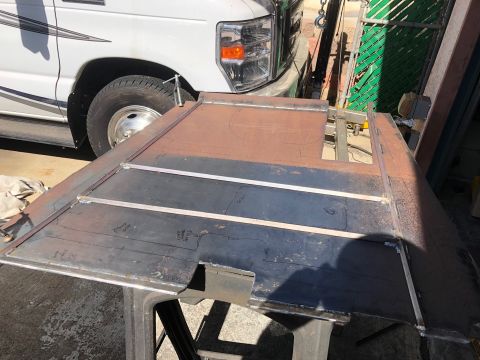 1992 Jeep Wrangler - Metal sheet being prepared for fabrication, with a white van visible in the background.