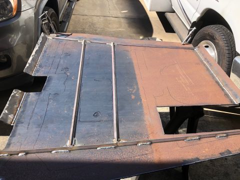 1992 Jeep Wrangler - A custom-fabricated metal panel with layout lines and welds is shown outdoors next to two vehicles.