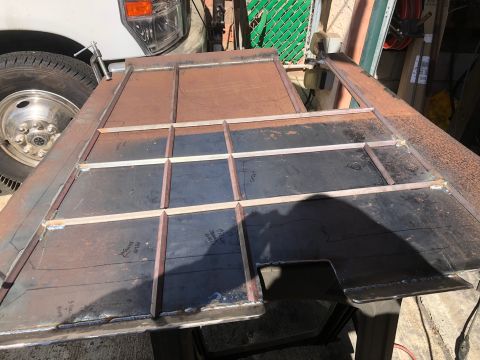 1992 Jeep Wrangler - A metal frame with a grid pattern is being worked on, with a truck wheel visible in the background.
