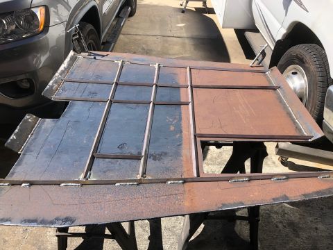 1992 Jeep Wrangler - A custom metal part, likely for a vehicle frame, is shown next to a gray SUV and a white van.
