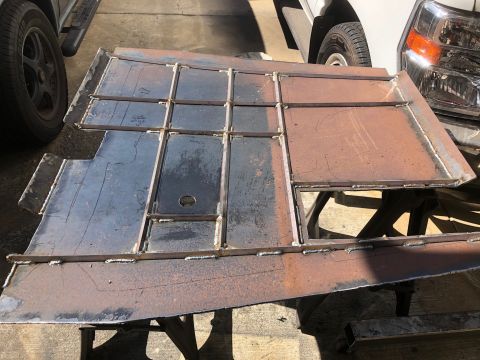 1992 Jeep Wrangler - A fabricated metal panel with a grid of welded sections is shown, with parts of two vehicles visible in the background.