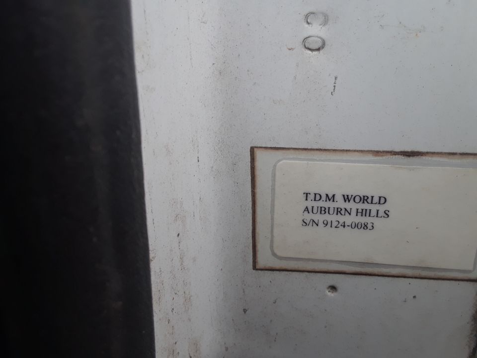 Label with text T.D.M. WORLD AUBURN HILLS S/N 9124-0083