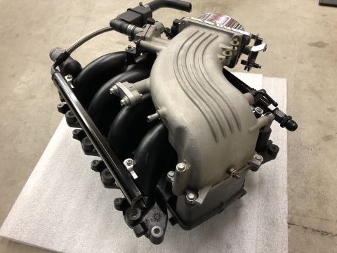 1998 Ford Crown Victoria - An engine intake manifold assembly is shown from a high angle, with black runners and a silver throttle body housing.