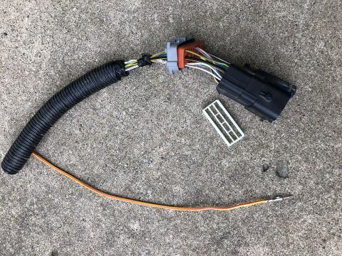 2015 Ford Explorer - Wiring harness with black corrugated tubing and a black connector lies on a concrete surface.