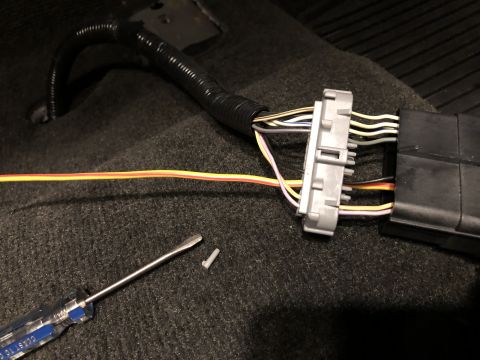 2015 Ford Explorer - Wiring harness disconnected in a car's interior, with a screwdriver nearby.