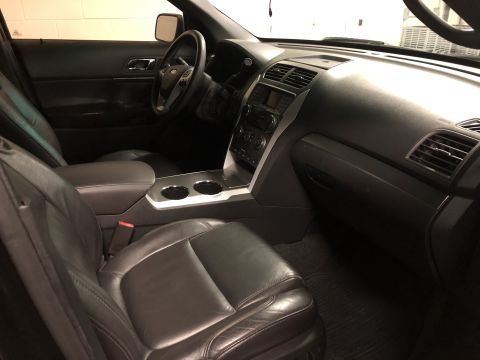 2015 Ford Explorer - The interior of a Ford Explorer shows black leather seats and the dashboard area.