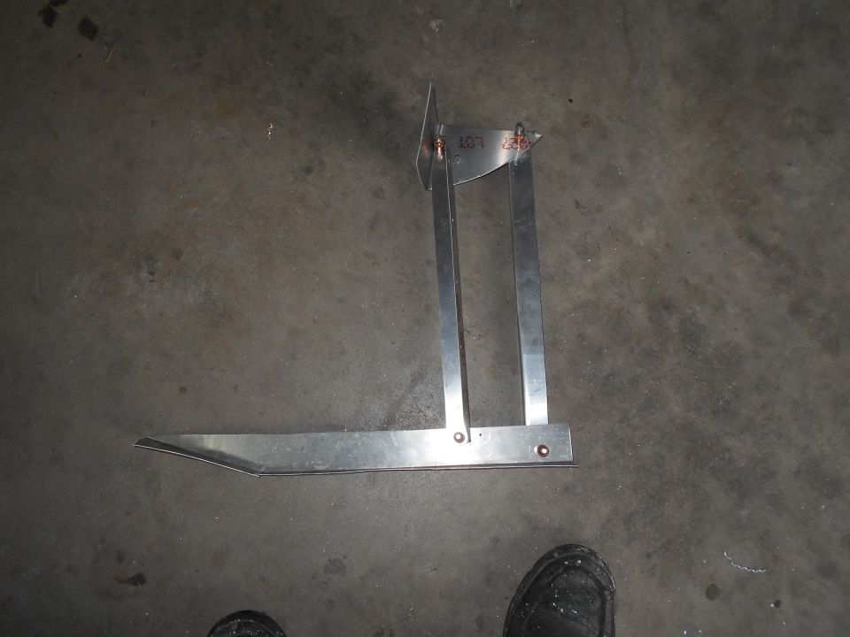 Metal measuring tool with a long flat arm and a vertical arm with an adjustable pointer