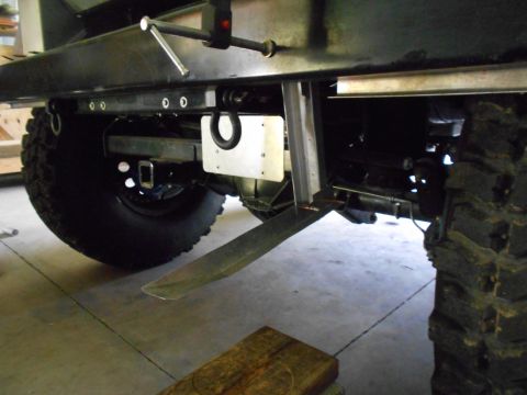 1992 Ford Bronco - Close-up view of the rear axle and suspension system, showing heavy-duty tires and a tow hitch assembly.