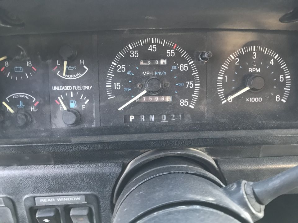 1988 Ford Bronco dashboard with speedometer, tachometer, fuel gauge, oil pressure gauge, and battery voltage gauge. Odometer shows 275986