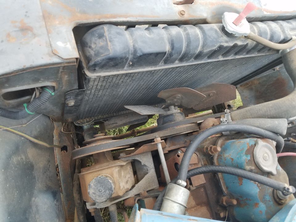 1977 Jeep CJ5 engine bay showing radiator, fan, belts, and engine block