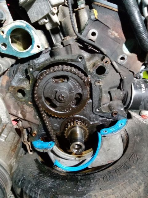 1994 Ford Bronco - Close-up of engine timing chain and gears during repair.