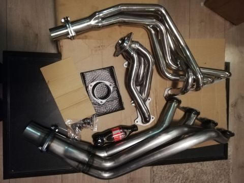 1996 Ford Bronco - Exhaust headers and parts are shown laid out on a floor.