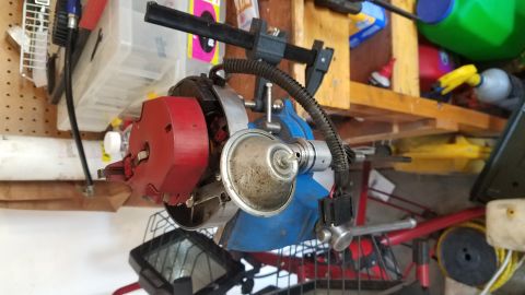 1985 Ford Bronco - A vehicle distributor part is shown, clamped in a vise, with various items in the background.