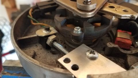 1985 Ford Bronco - Close-up view of the internal components of a vehicle's distributor cap, including wiring and metal parts. The Supermotors.net logo is visi…