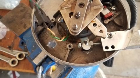 1985 Ford Bronco - Close-up of a vehicle's distributor cap and rotor assembly, secured in a vise.