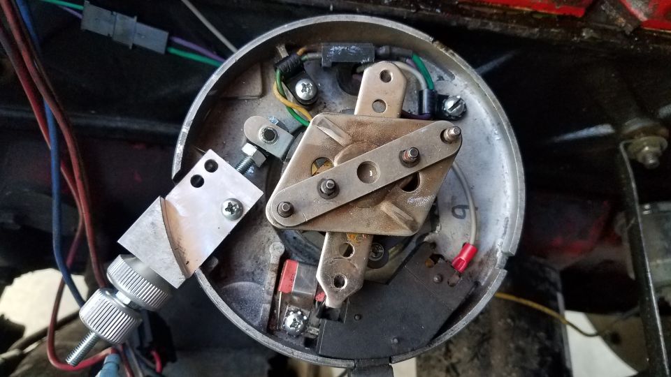 Close-up of an automotive ignition distributor with visible points and condenser