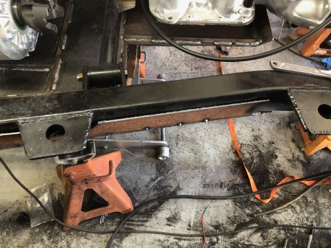 1992 Jeep Wrangler - Close-up view of a vehicle's frame and engine components, supported by orange jack stands.