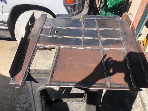 1992 Jeep Wrangler - A custom metal frame section is shown, with a partial view of a white vehicle's wheel and fender in the background.
