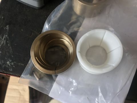 1989 Ford Bronco - Two new suspension bushings, one metal and one plastic, are shown side-by-side.