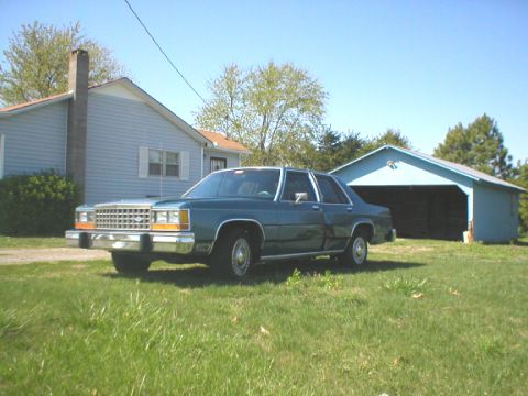 1987 Ford Crown Victoria LTD - 1987 Ford Crown Victoria LTD parked in front of a blue garage on a sunny day.
