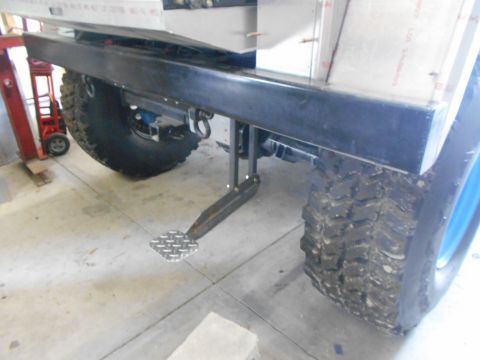 1992 Ford Bronco - Close-up view of the rear bumper and tire assembly, a custom diamond plate step.