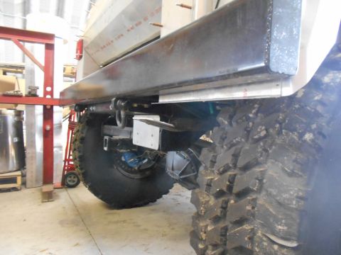 1992 Ford Bronco - The rear suspension and massive tire of a custom off-road vehicle are visible in this close-up shot.