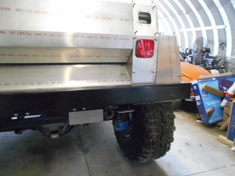 1992 Ford Bronco - The rear of a custom vehicle with aluminum body panels and a large off-road tire is visible.
