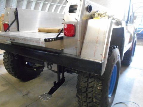 1992 Ford Bronco - This custom aluminum truck bed features a red taillight and a diamond plate step, with a visible Supermotors.net watermark.