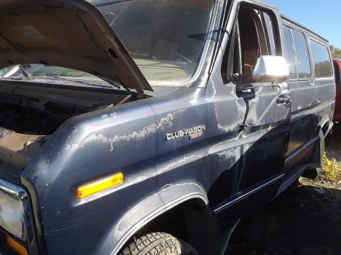 1994 Ford Bronco - This van has seen better days, with peeling paint and an open hood revealing the engine bay.