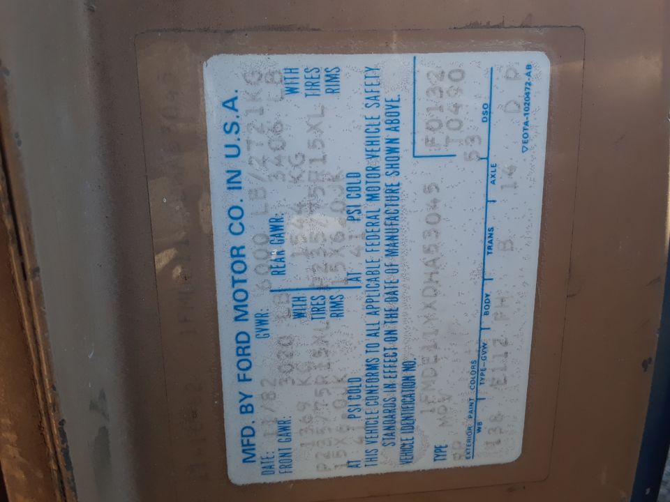 Faded early-1980s Ford Motor Co. U.S.A. door certification label with GVWR, tire and code fields