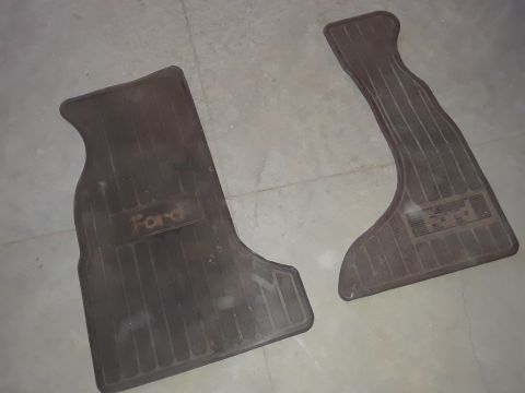 1994 Ford Bronco - A pair of Ford branded rubber floor mats are shown on a concrete surface.