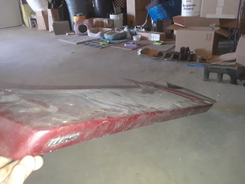 1994 Ford Bronco - A red car part, possibly a fender or door, displays the LUND logo.