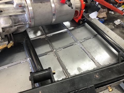 1992 Jeep Wrangler - Custom frame modification with transmission assembly in a workshop setting.