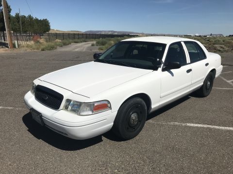 1987 Ford Bronco II - This white sedan, likely a Ford Crown Victoria, is viewed from a three-quarter front angle on a paved surface.