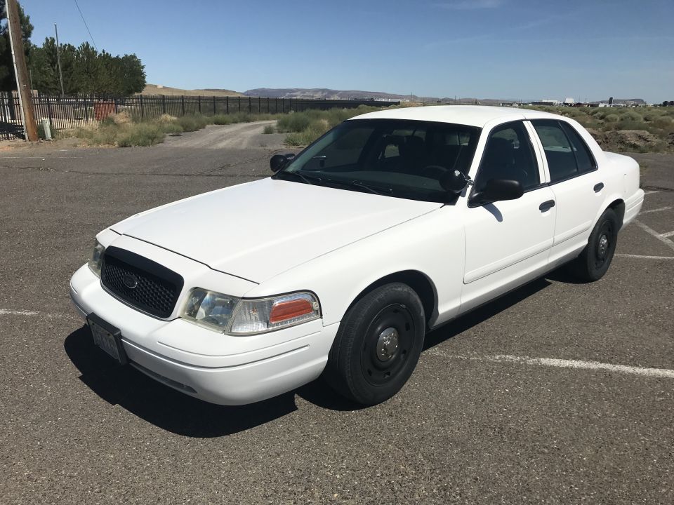White sedan with black grille and steel wheels, parked on asphalt