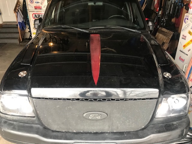 Black Ford Ranger truck front end with a red accent on the hood