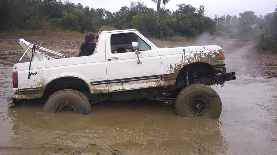 White Ford Bronco stuck in mud, 1987 model