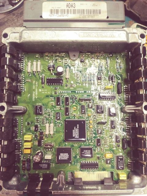 1996 Ford Bronco - Close-up of an engine control unit circuit board, showing intricate electronic components and labeling.