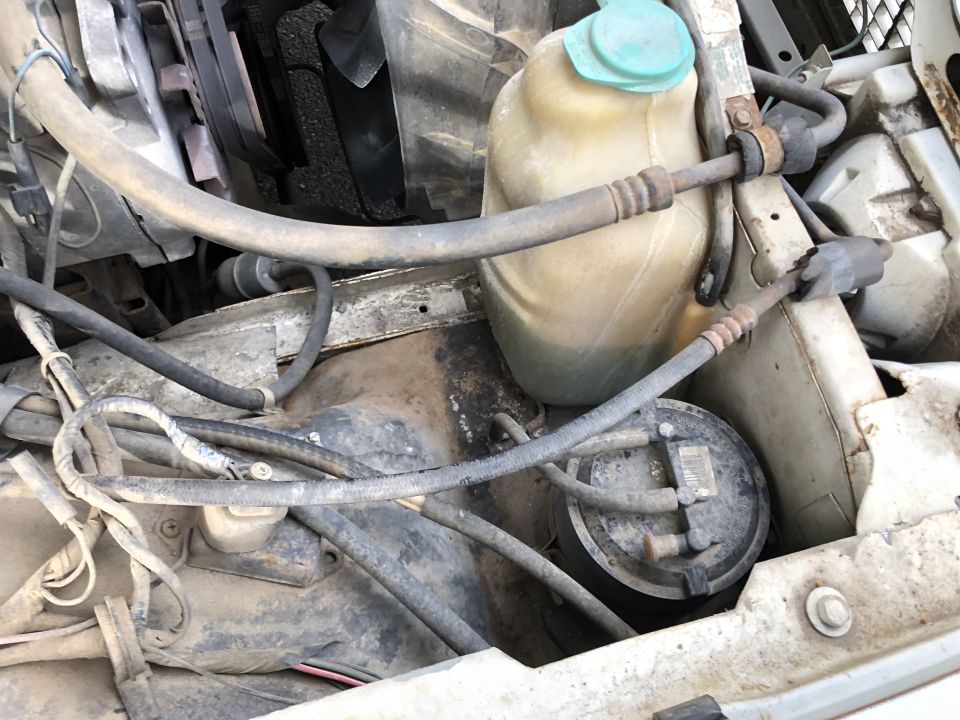 engine bay with hoses, belts, and fluid reservoir