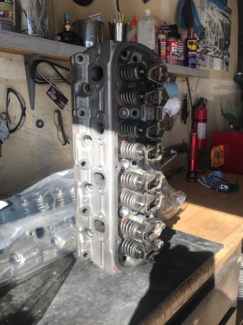 2000 Ford Explorer - A close-up view of an engine cylinder head, showing its internal components like valves and springs, resting on a workbench.