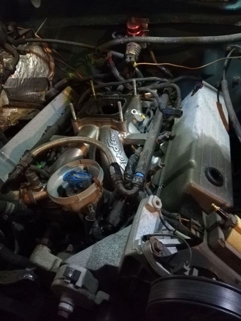 1996 Ford Bronco - Close-up view of a vehicle's engine bay, showing complex wiring and plumbing.