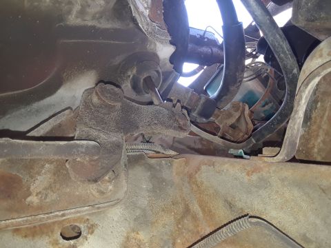 1994 Ford Bronco - Close-up view of rusty undercarriage components and hoses on a vehicle.