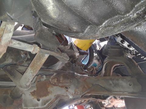 1994 Ford Bronco - The underside of a 1994 Ford Bronco reveals its suspension system, including control arms and a prominent yellow oil filter.
