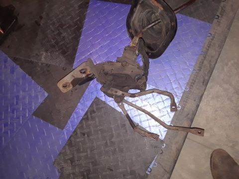 1994 Ford Bronco - This manual transmission shifter assembly, likely from a Ford Bronco, is shown removed from the vehicle and resting on a patterned floor.