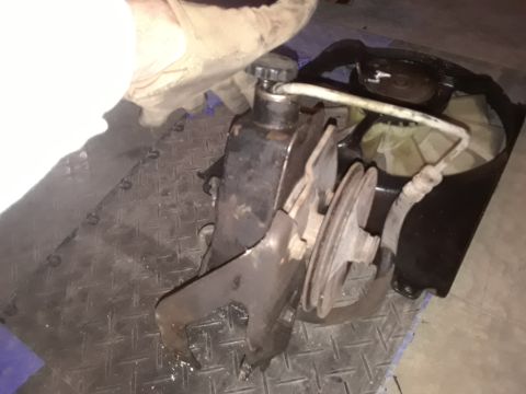 1994 Ford Bronco - Close-up of a removed power steering pump and fan shroud assembly.