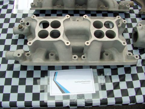1969 Ford Mustang - A Ford Dual Quad intake manifold is displayed on a checkered tablecloth.